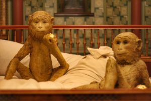 Two monkey sculptures on a bed