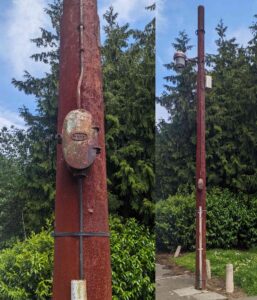 An old rusty pole with electric cable and box